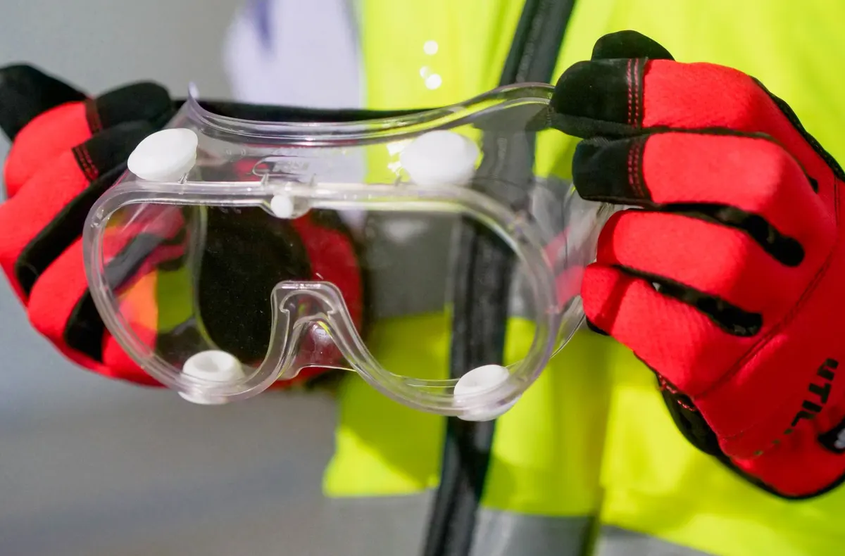 Hi-vis vest, safety goggles and work gloves